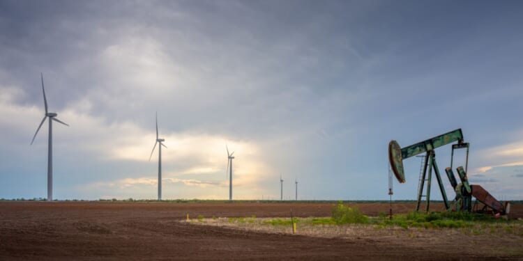 An oil pumpjack is seen near a field of wind turbines on Oct. 4, 2023, in Nolan, Texas.