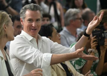 The Governor of California Gavin Newsom speaks with a woman during the COP30 UN Climate Change Conference, in Belem, Para State, Brazil, on November 11, 2025.