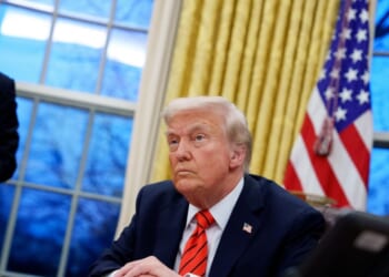 President Donald Trump, accompanied by White House Staff Secretary Will Scharf, appears at the Resolute Desk as he signs a series of executive orders including 25 percent tariffs on steel and aluminum, a pardon for former Illinois Gov.