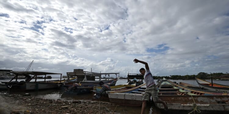 A fisherman prepares to sail off from an artisanal dock and participate in the search for victims of a shipwreck in Guiria, Venezuela, on Dec. 18, 2020.