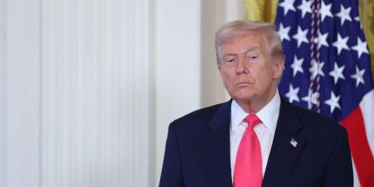 President Donald Trump listens as First Lady Melania Trump speaks at a signing ceremony for the "Fostering the Future" executive order in the East Room of the White House on Nov. 13, 2025, in Washington, D.C.