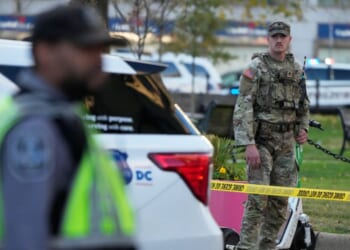 National Guardsmen and emergency personnel gather near the area where two National Guard soldiers were reportedly shot and killed by a lone gunman near the White House in Washington, DC on Nov. 26, 2025.