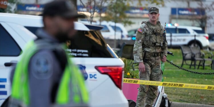 National Guardsmen and emergency personnel gather near the area where two National Guard soldiers were reportedly shot and killed by a lone gunman near the White House in Washington, DC on Nov. 26, 2025.