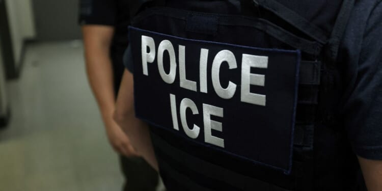An Immigration and Customs Enforcement (ICE) agent stands in a hallway outside of a courtroom in the New York Federal Plaza Immigration Court in New York on July 17, 2025.