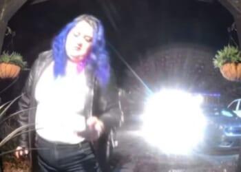 A DoorDash driver with blue hair was allegedly caught by a doorbell camera spiking an innocent woman's meal.