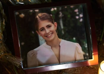 Candles are lit by a framed photo of mass shooting victim Ella Cook at a makeshift memorial near Brown University in Providence, Rhode Island, on Dec. 15, 2025.