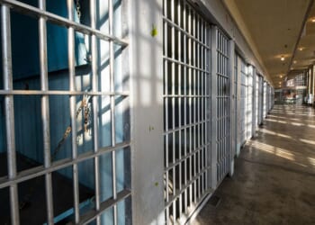 The sun shines on the bars in a prison.