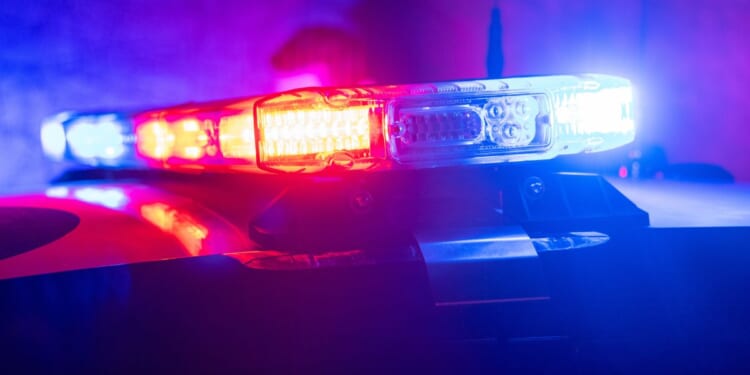 Red and blue lights flash on top of a police car.