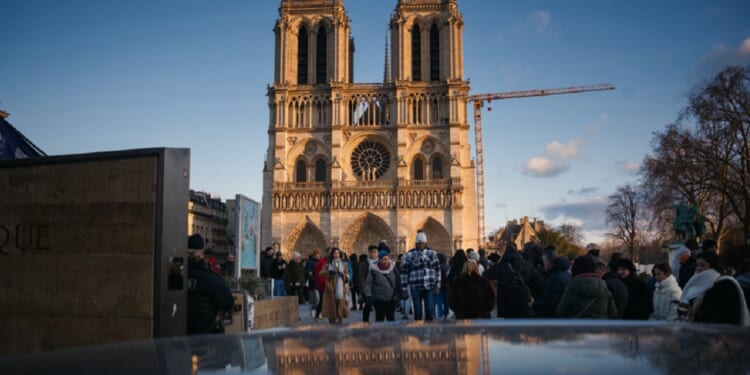 Notre Dame Cathedral looms large over pedestrians in Paris on Christmas Eve.