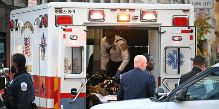 An unidentified man in military fatigues lies on a stretcher inside an ambulance on Nov. 26, 2025, in downtown Washington, D.C.
