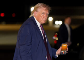 President Trump holds a cellphone during a call as he boards Air Force One at Rocky Mount-Wilson Regional Airport in Elm City, North Carolina, on Dec. 19, 2025.