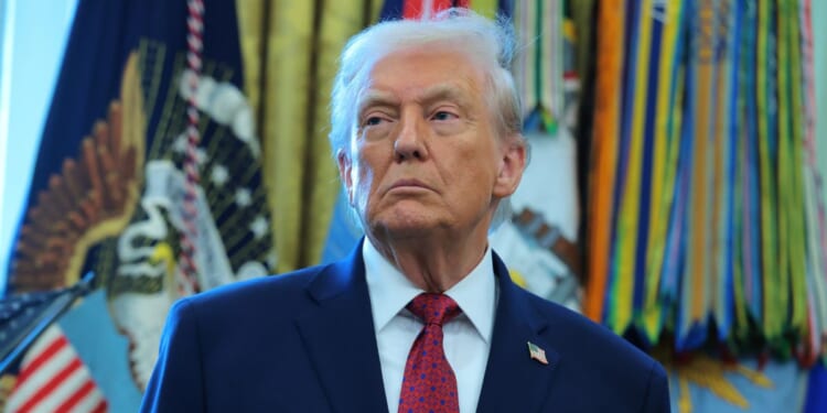 President Donald Trump listens during a ceremony in the Oval Office of the White House in Washington, DC on Dec. 15, 2025.