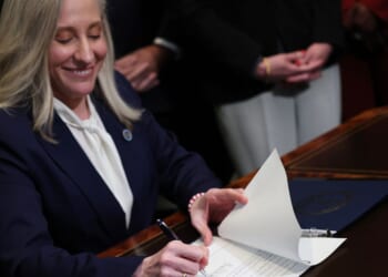 Virginia Governor Abigail Spanberger grins as she signs executive orders shortly after being sworn in as governor at the Virginia State Capitol in Richmond, Virginia, on Jan. 17, 2026.