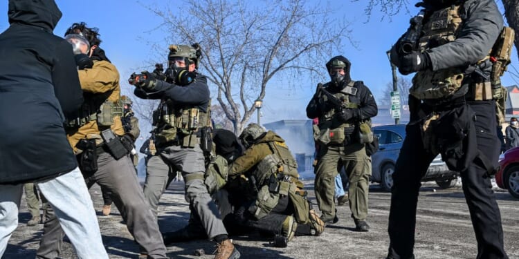 A person is tackled by federal agents as unrest escalates in Minneapolis, Minnesota, on Jan. 24, 2026.