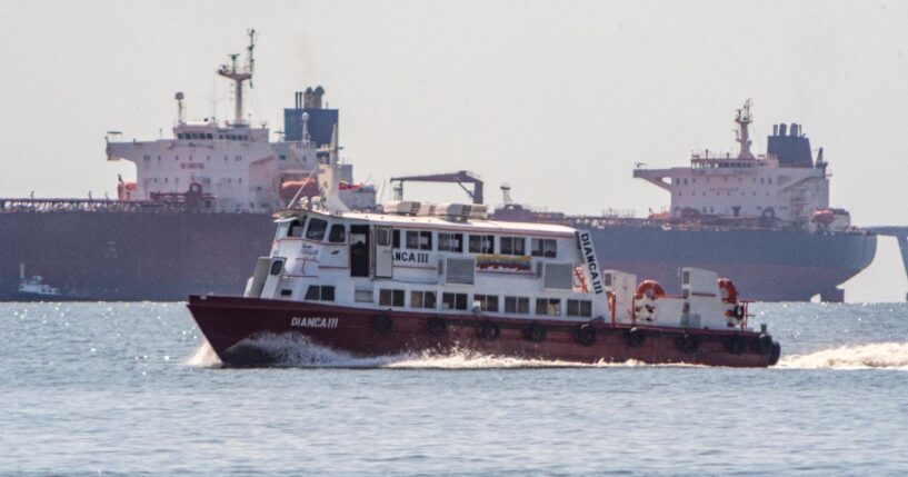 A boat sails in front of a crude oil tanker anchored on Lake Maracaibo near Maracaibo, Zulia state, Venezuela, on Dec. 18, 2025.