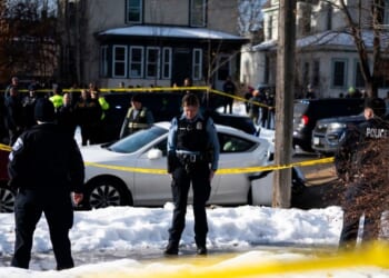 Minneapolis Police officers stand at the scene of a shooting where a law enforcement officer "fearing for his life" shot and killed a woman who actively impeded an ICE operation, refused to follow lawful orders, and then drove straight at said officer in Minneapolis, Minnesota, on Jan. 7, 2026.