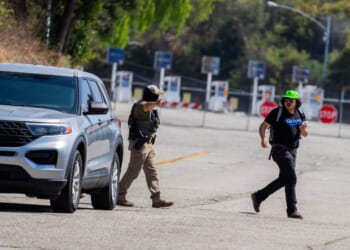 A federal agent gestures toward a National Lawyers Guild legal observer attempting to record license plates near Gate E of Dodger Stadium during a brief confrontation on June 19, 2025, in Los Angeles, California.