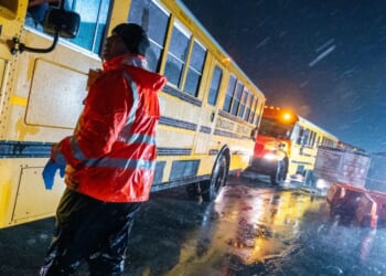 School buses drive through a storm in the Brooklyn borough of New York City on Jan. 9, 2024.