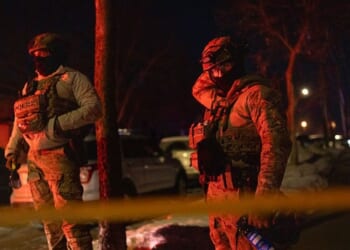 Two federal agents guard a perimeter following a shooting in Minneapolis, Minnesota, on Jan. 14, 2026.