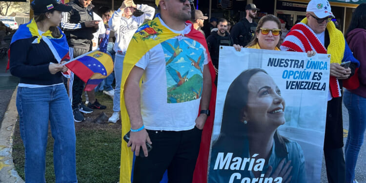 David Nuñez, Lisbeth Garcia, and Victor Gimenez gather outside El Arepazo restaurant with a banner of opposition leader and Nobel Peace Prize winner Maria Corina Machado amid celebrations following news of Venezuelan President Nicolás Maduro's capture in Doral, Florida, on Jan. 3, 2026.