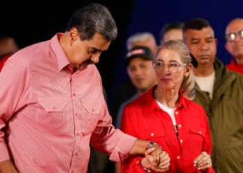 Venezuela's President Nicolas Maduro dances with his wife Cilia Flores during a demonstration for the swearing-in of Bolivarian committees in Caracas on November 15, 2025.