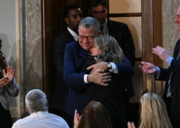Former Venezuelan presidential candidate and recently released prisoner Enrique Márquez embraces a family member as he is being recognized by President Donald Trump at the State of the Union address in the House Chamber of the US Capitol in Washington, DC on Feb. 24, 2026.