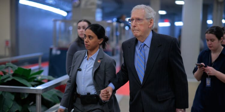 Sen. Mitch McConnell is assisted by U.S. Capitol Police as he heads for a vote on Jan. 14, 2026, in Washington, D.C.