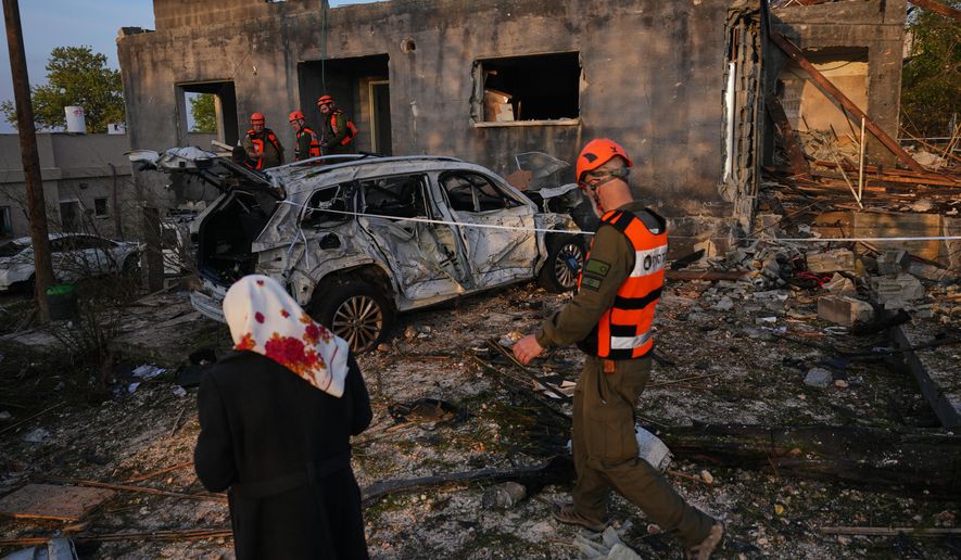 Residents and officers from Israel's Home Front Command inspect a house destroyed by an Iranian missile strike in Zarzir, northern Israel, Friday, March 13, 2026. (AP Photo/Ariel Schalit)