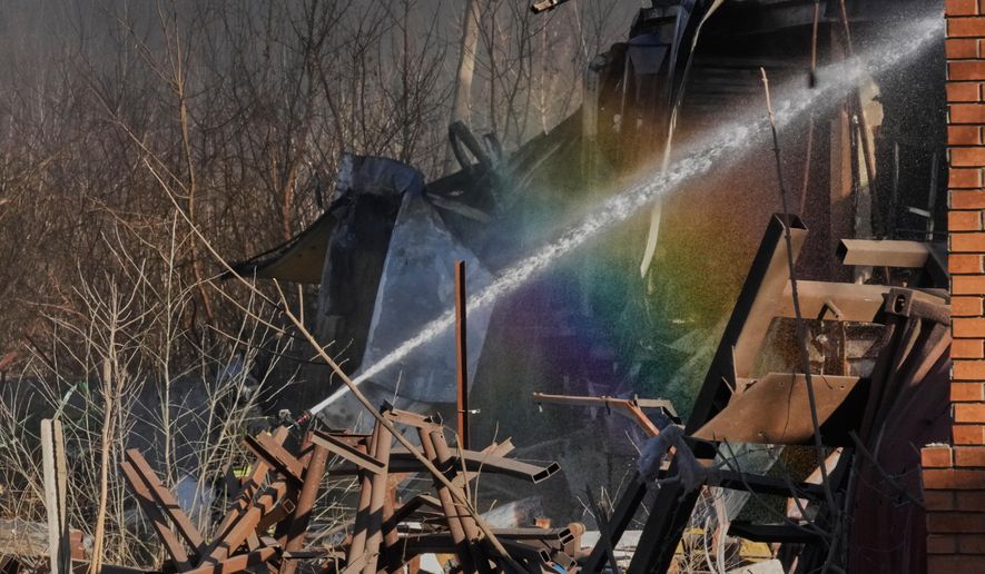 Firefighters put out the fire at railway workshops following a Russia missile and drone attack, in Brovary close to Kyiv, Ukraine, Saturday, March 14, 2026. (AP Photo/Efrem Lukatsky)