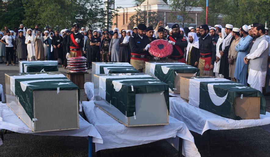 People attend the funeral prayers of police officers, killed in the roadside bomb explosion, outskirts of Lakki Marwat, a district in northwest Pakistan, Friday, March 13, 2026. (AP Photo/G.A. Marwat)