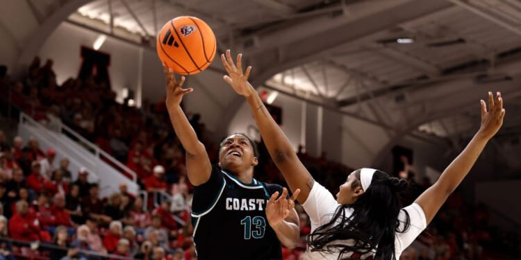 Tracey Hueston of the Coastal Carolina Chanticleers puts up a shot against Mallory Collier of the NC State Wolfpack in the second half at Reynolds Coliseum on Nov. 19, 2025, in Raleigh, North Carolina.