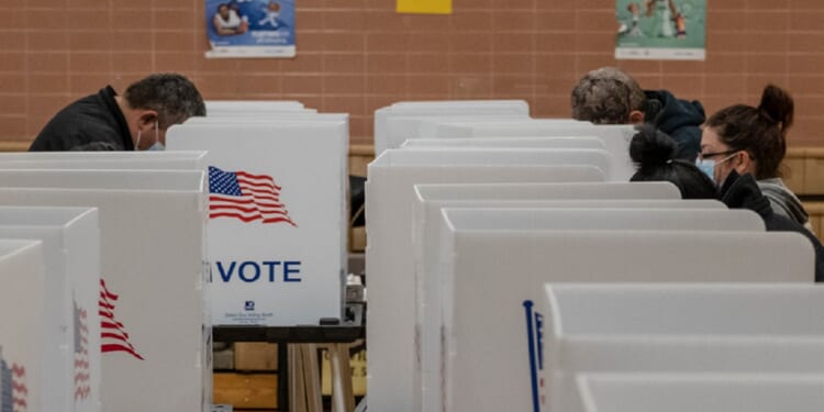 Masked voters cast their ballots at a polling place in the pandemic-era 2020 presidential election.