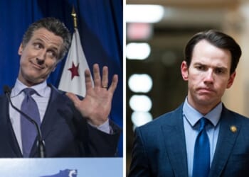 Gavin Newsom stands at podium during gubernatorial primary election watch party as Kevin Kline walks silently in a hallway.