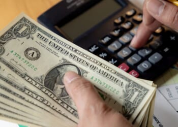 A man does some financial planning on a desk.