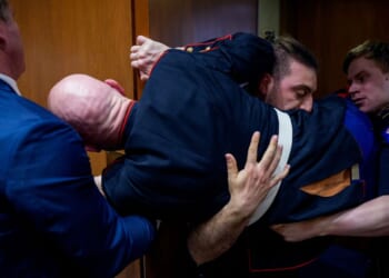 Protester Brian McGinnis is dragged out of a Senate Armed Services Subcommittee hearing on Capitol Hill and is stuck in a door on March 4, 2026.