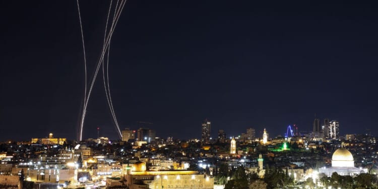 Rocket trails from an interception by Israel's Iron Dome missile defense system are pictured over Jerusalem on March 1, 2026.