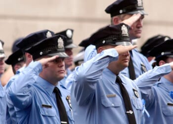 Philadelphia police officers salute as pallbearers carry the casket of Philadelphia Police Officer Gennaro Pellegrini Jr. to St. Anne's Church for a funeral mass on Aug. 20, 2005, in Philadelphia, Pennsylvania.