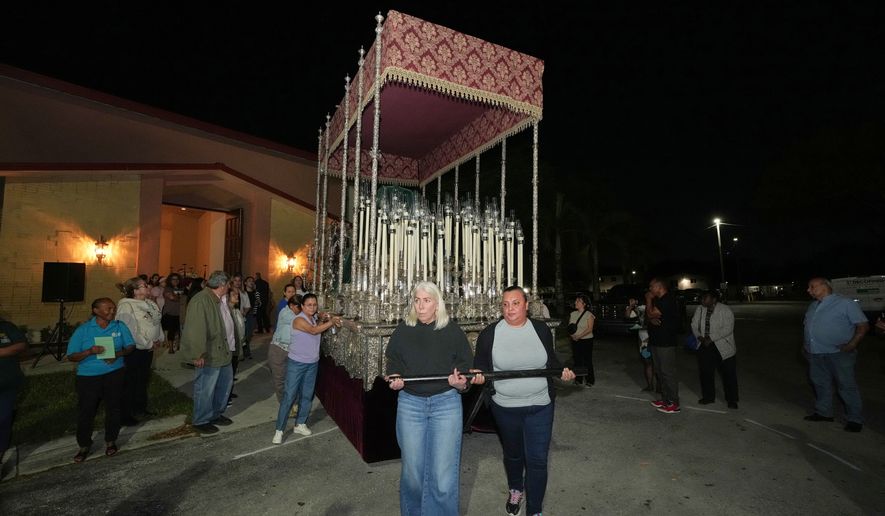 Corpus Christi Catholic Church members push a large float that will carry the Lady of Hope Macarena during a rehearsal for their Good Friday procession, Monday, March 23, 2026, in Miami, Fla. (AP Photo/Marta Lavandier)