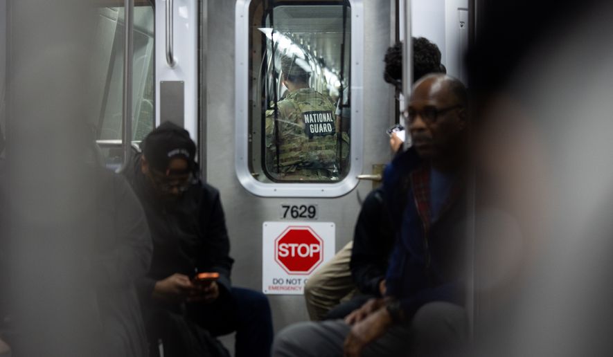 A member of the National Guard rides the Metro on Monday, March 23, 2026, in Washington. (AP Photo/Allison Robbert)
