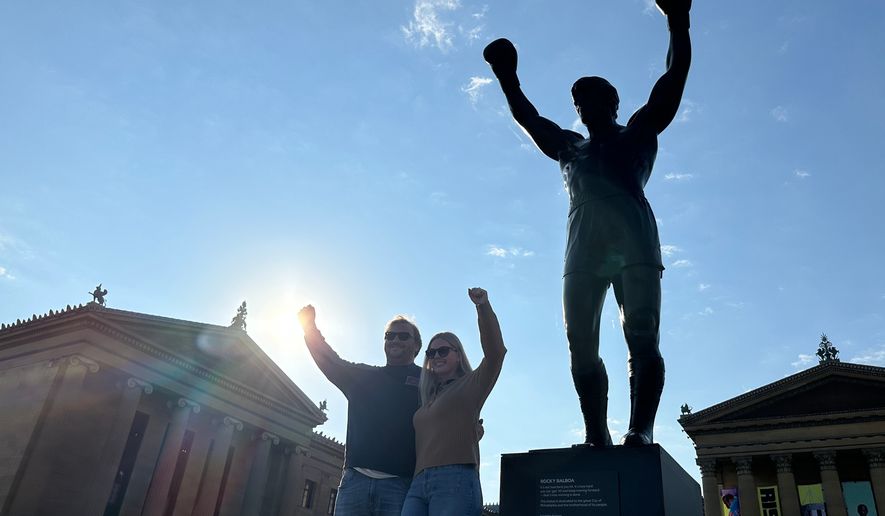Visitors pose in front of the Rocky statue at the Philadelphia Museum of Art in Philadelphia, on Wednesday, April 22, 2026 (AP Photo/Tassanee Vejpongsa)