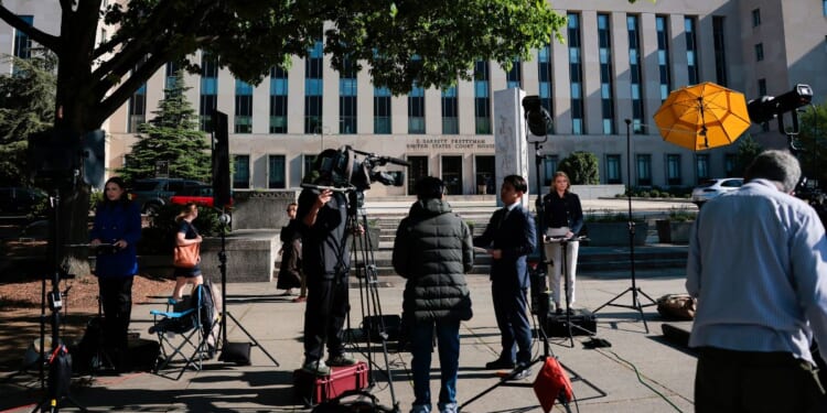 Members of the news media set up outside the E. Barrett Prettyman United States Court House Monday in Washington, D.C., where the alleged White House Correspondents' Dinner gunman, Cole Allen, was expected to be arraigned.