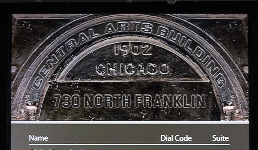 Global Tetrahedron, LLC, owner of The Onion, is displayed on the entrance screen to the office building that is headquarters to the satirical publication, Thursday, Nov. 14, 2024 in Chicago. The Onion won the bidding for Alex Jones'Infowars at a bankruptcy auction, backed by families of Sandy Hook Elementary School shooting victims whom Jones owes more than $1 billion in defamation judgments for calling the massacre a hoax. (AP Photo/Teresa Crawford)