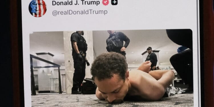 A cell phone displays a social media post picturing a suspect identified as Cole Allen restrained on the floor after Saturday's assassination attempt against President Donald Trump and members of his administration in a shooting at the White House Correspondents' Association dinner in Washington, D.C.