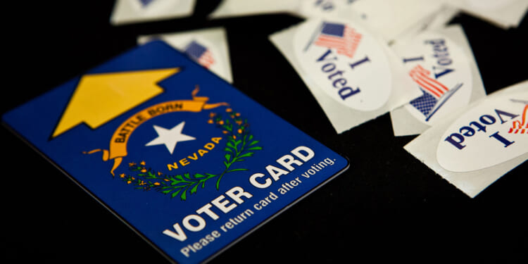 A Nevada voting card surrounded by "I Voted" stickers on a black background.