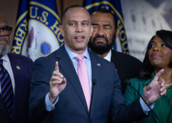 Hakeem Jeffries points upward during press conference with fellow Democrats.