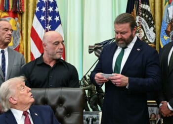Health and Human Services Secretary Robert F. Kennedy Jr., President Donald Trump, and media personality Joe Rogan listen as W. Bryan Hubbard, CEO of Americans for Ibogaine, speaks before Trump signs an executive order in the Oval Office of the White House in Washington, D.C., on April 18, 2026.