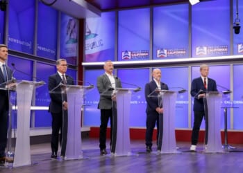 Six California gubernatorial candidates stand at podiums during a debate on April 22, 2026.