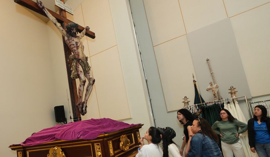 Corpus Christi Catholic Church youth members look up at a statue of Jesus crucified during a rehearsal for their Good Friday procession, Monday, March 23, 2026, in Miami, Fla. (AP Photo/Marta Lavandier)