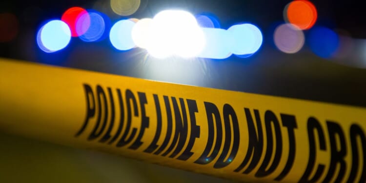 A crime scene at night covered by police tape.