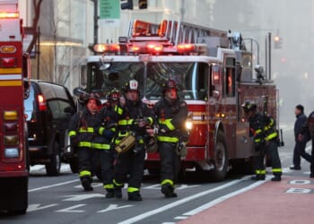 Firefighters from the New York City Fire Department workout the scene of the fire amidst heavy smoke in Midtown Manhattan on March 17, 2026.